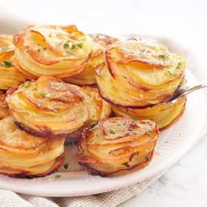 stacks of sliced cooked potato on a white plate