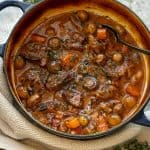 beef stew with mushrooms and carrot in blue pot
