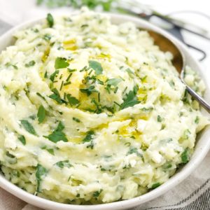 white mashed potatoes with green spinach sitting in a white bowl