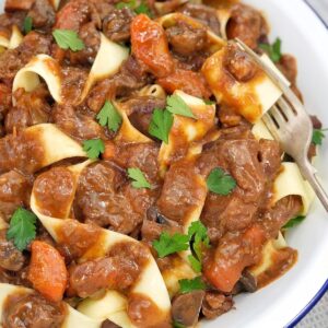 lamb ragu in a white dish with a fork