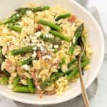 rice shaped pasta with chopped asparagus in a white bowl