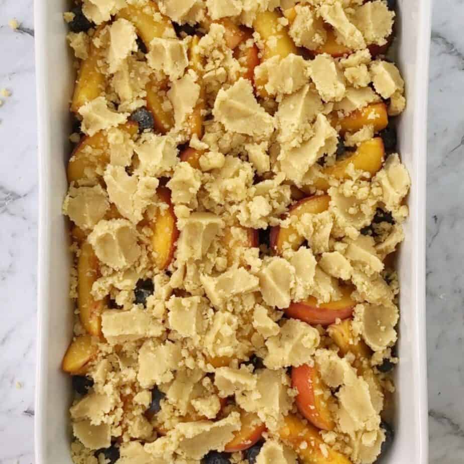 blueberry and peach crumble in white baking dish