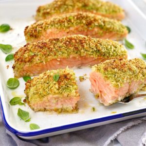 baked salmon fillets with pesto crust on a white baking tray