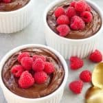 brown creamy mousse in a white bowl with raspberries on top