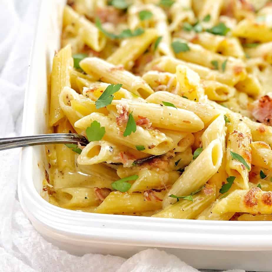 penne pasta with creamy sauce in a white baking dish