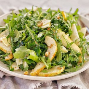 rocket leaves and sliced pears on a white plate