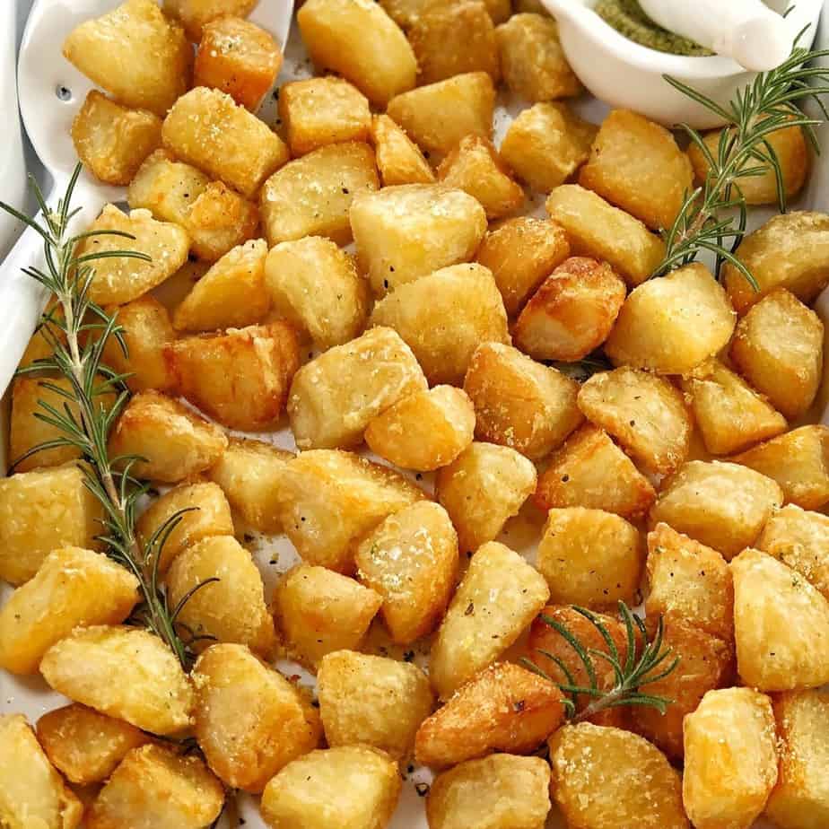 cubes of crisp potatoes in a white baking tray