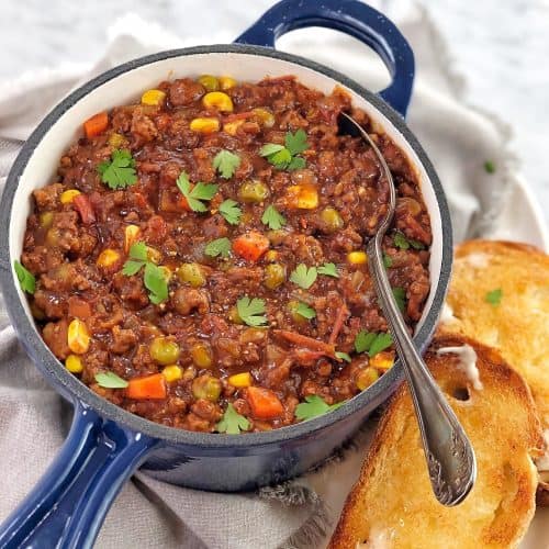 mince and vegetables in a blue saucepan with slices of toast on the side