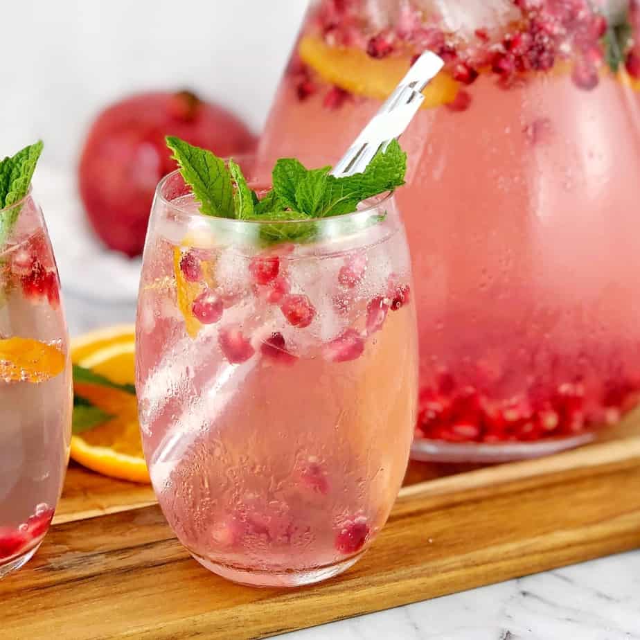 cocktail with pomegranate and mint in a glass on a board