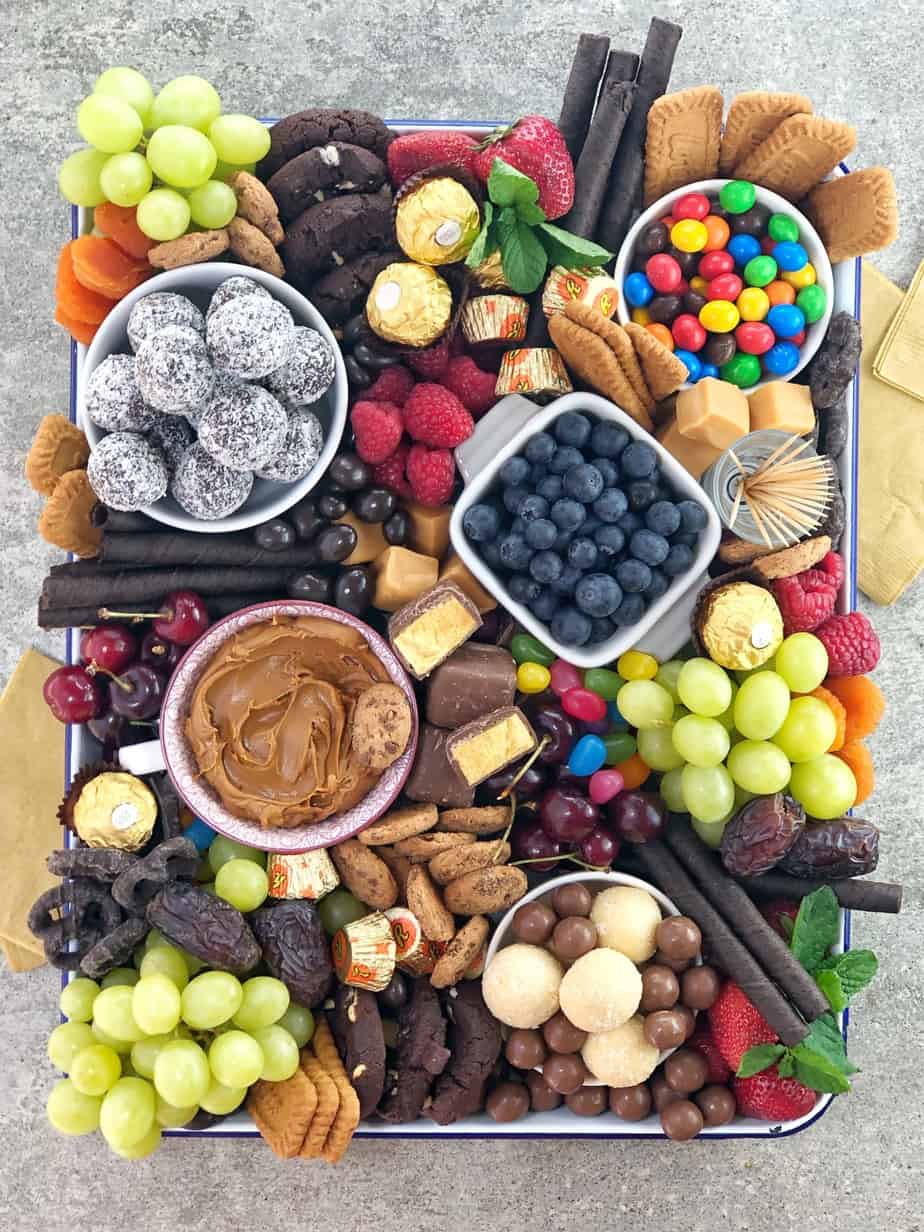 various chocolates sweets and fruit in a white baking dish