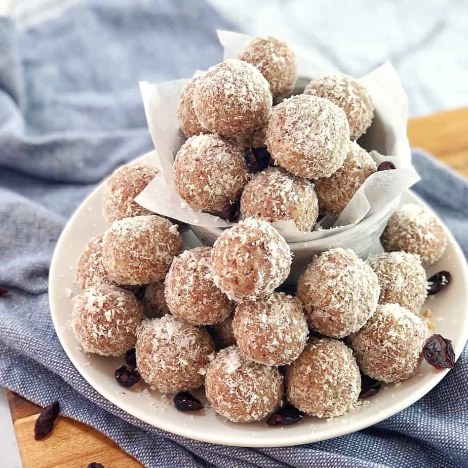 white chocolate and cranberries balls rolled in coconut on a white plate