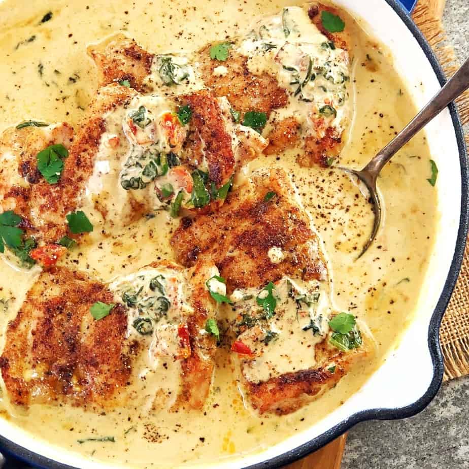 fried tuscan chicken thighs sitting in a cream sauce in a pan