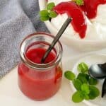 strawberry coulis in a glass jar with a spoon and mint
