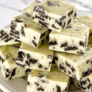 pieces of white chocolate and oreo fudge on a white plate.