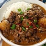 Beef curry with rice in a white bowl.