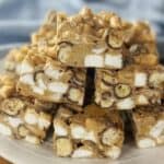 Pieces of rocky road sitting on a white plate.